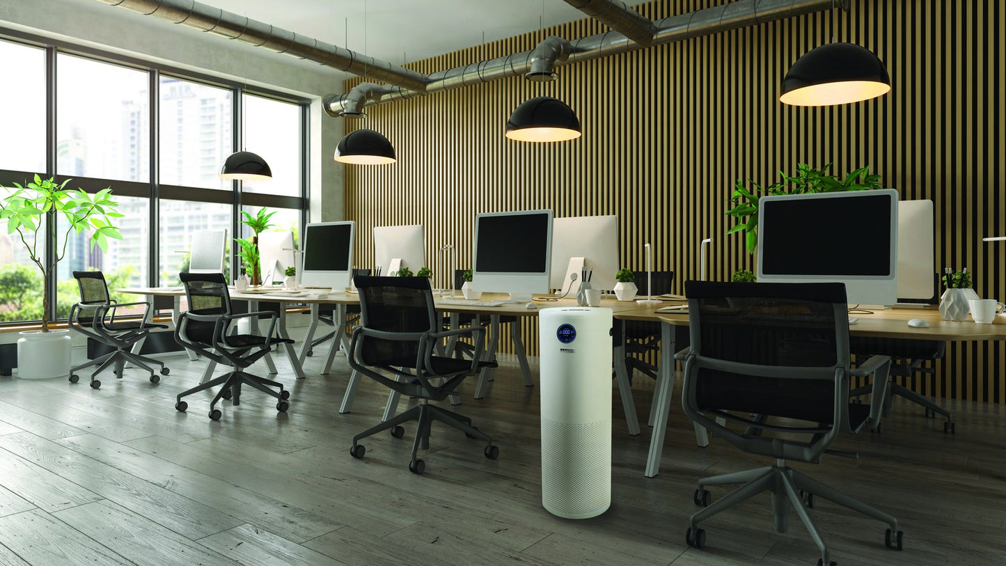 Surgically Clean Air JADE 2.0 air purifier standing in an open-plan office beside a workstation